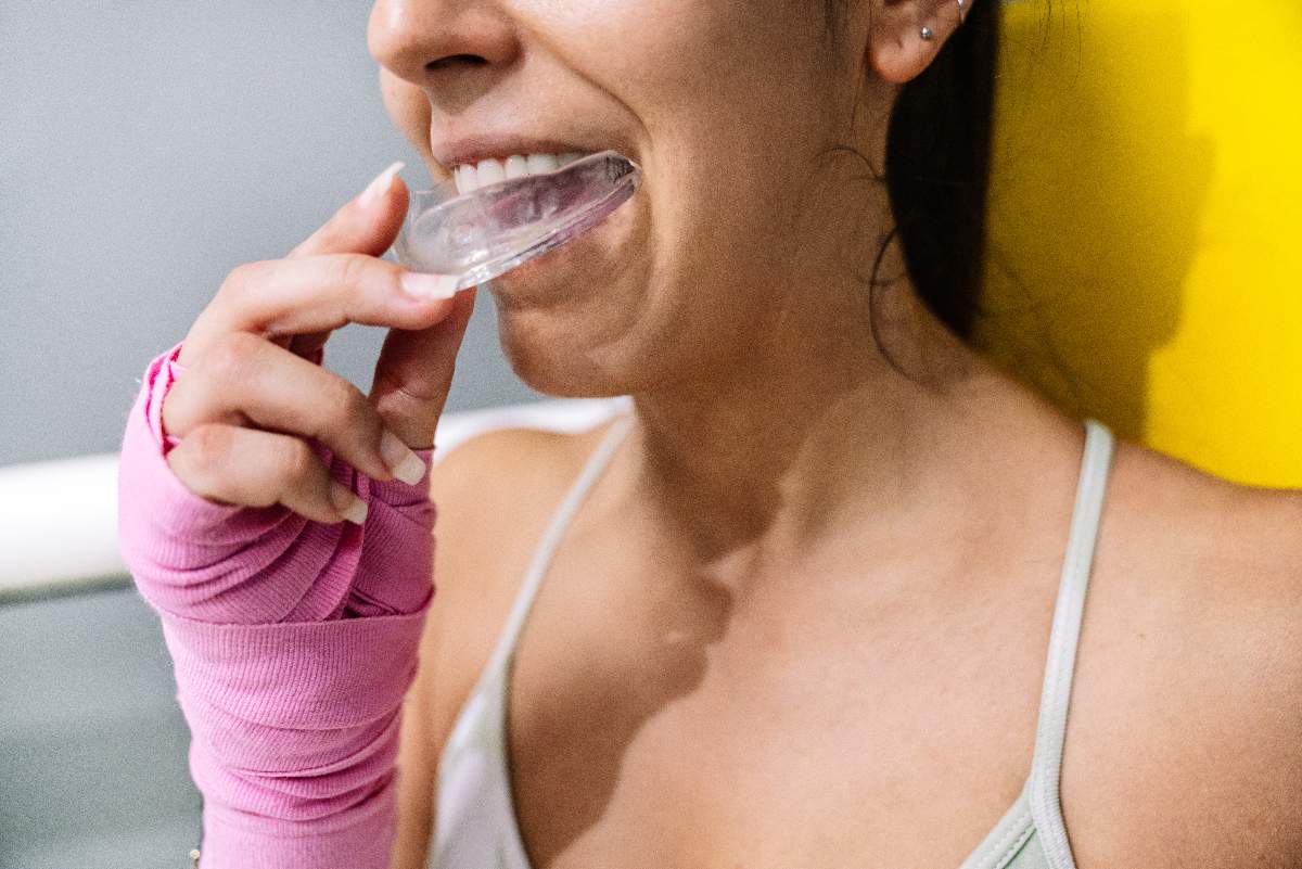 Woman inserting sport guard mouth guard