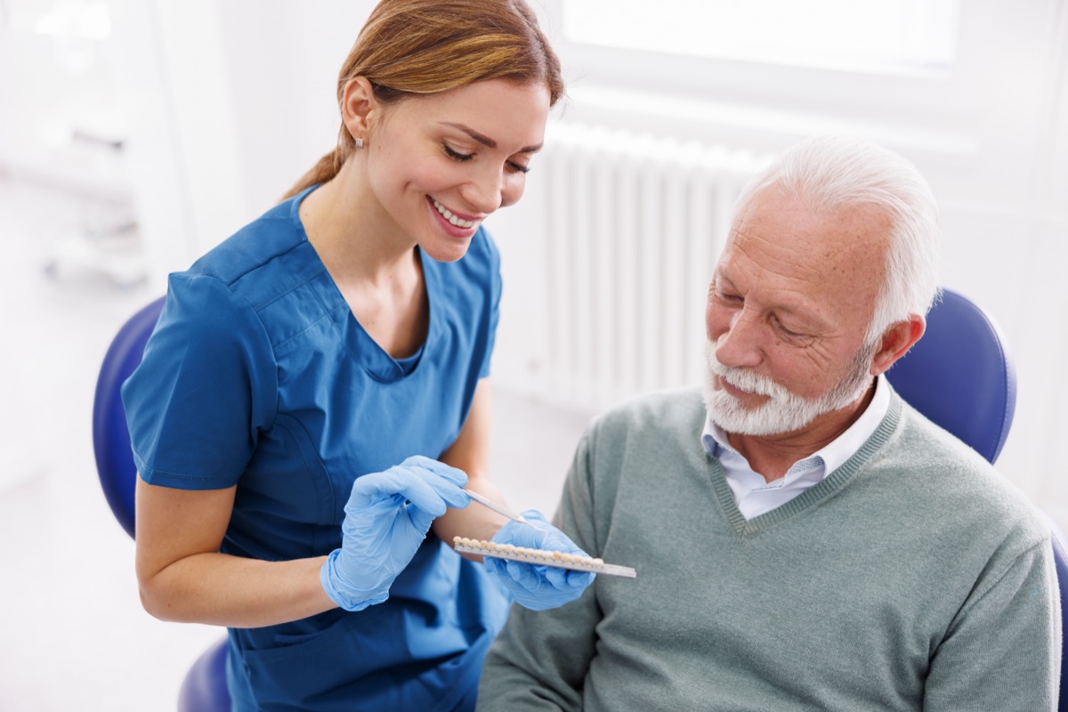 Dentist showing zirconium dental veneers color palette to patient